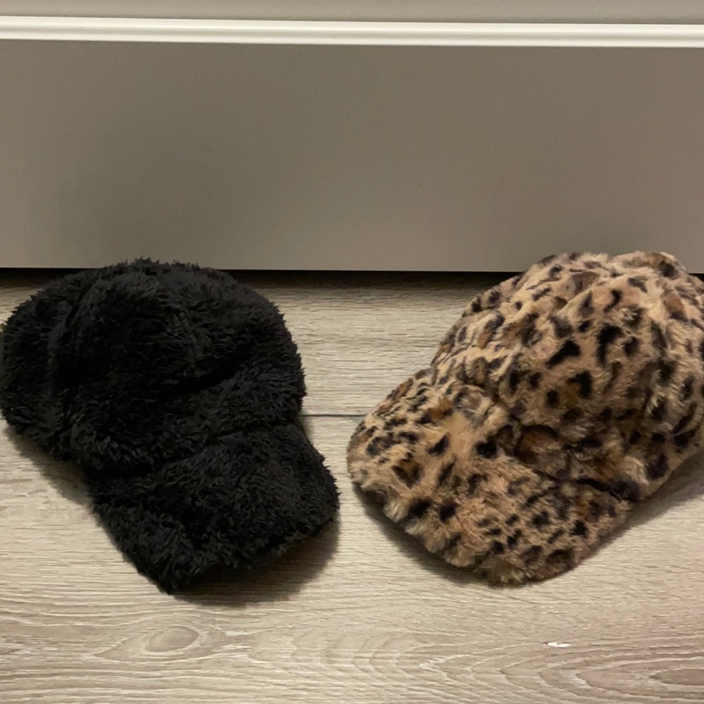 2 furry baseball hats. One is black the other leopard